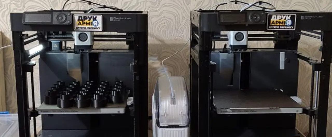 To 3D-printere med DrukArmy-klistremerker som printer deler