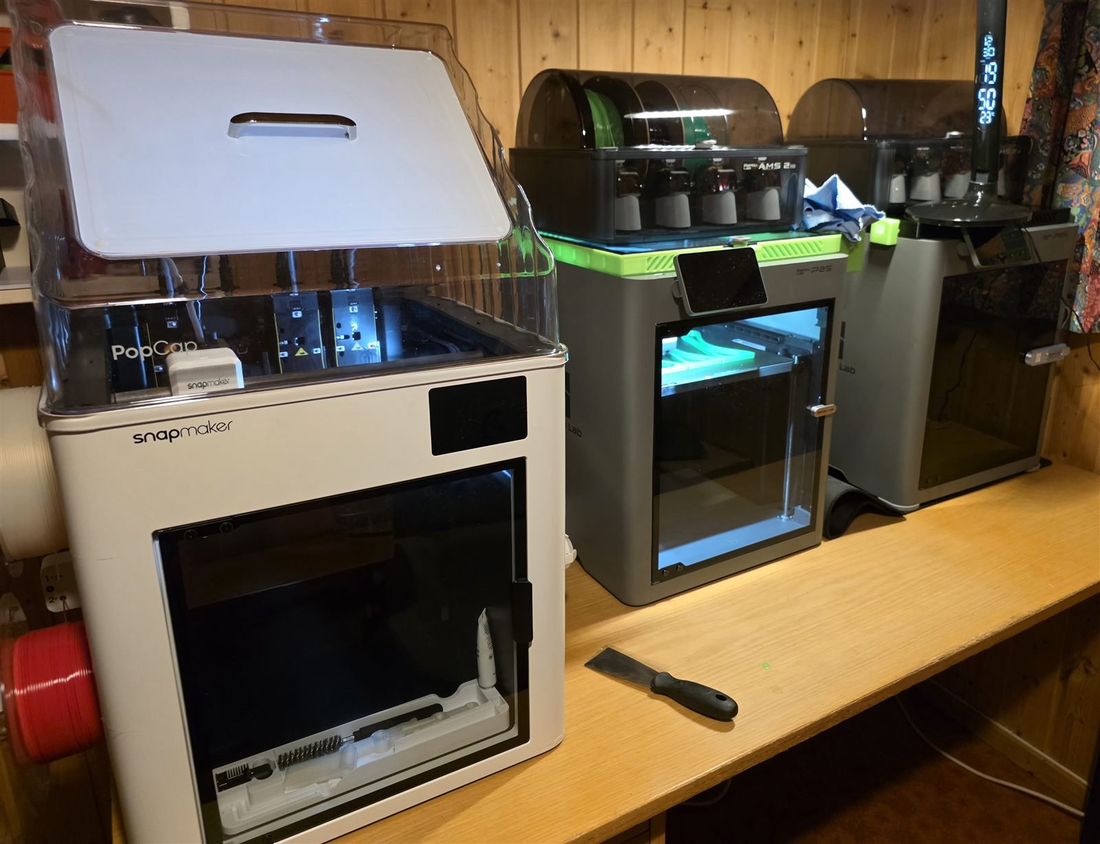 Printerkontoret: flere 3D-printere med filamentbokser på en arbeidsbenk
